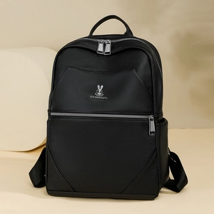 Detailed view of black lychee grain leather texture and silver bunny logo on the backpack