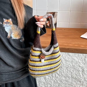 Detail of striped knit shoulder bag with cute handmade mushroom pendant accessory