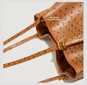 Close-up of adjustable shoulder strap and ostrich leather texture on a brown tote bag