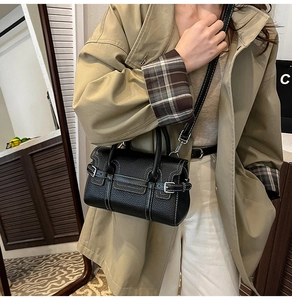 Detail einer schwarzen Handtasche aus Narbenleder mit Kontrastnähten und Silberbeschlägen
