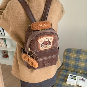 Detailed view of brown corduroy backpack with chef puppy embroidery and bread handle
