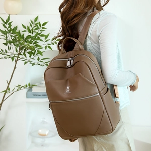 Brown lychee leather backpack showing detailed texture and silver rabbit logo on back