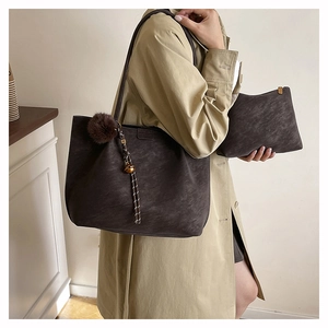 Detail of dark brown tote bag with matching small pouch and pompom pendant set
