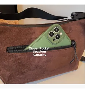 Detail view of large brown suede tote with zipper pocket holding a smartphone