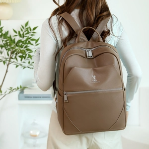 Brown lychee texture leather backpack featuring a top handle and adjustable shoulder straps