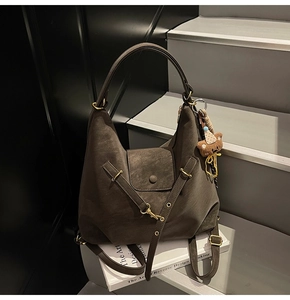 Detailed macro view of retro brown textured leather bag with gold hardware and bear charm