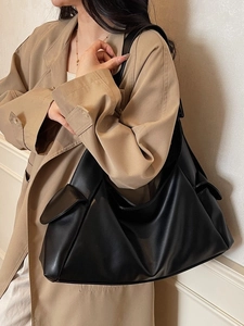 Sac fourre-tout minimaliste en similicuir noir avec poche latérale sur modèle