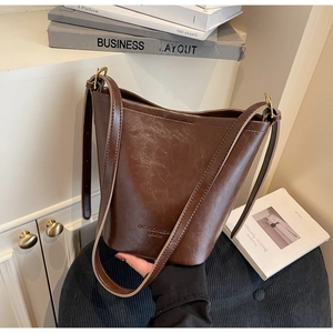 Top view of a dark brown vintage leather bucket bag with an adjustable shoulder strap