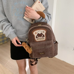 Detail of brown corduroy backpack with cute chef puppy toast embroidery patch