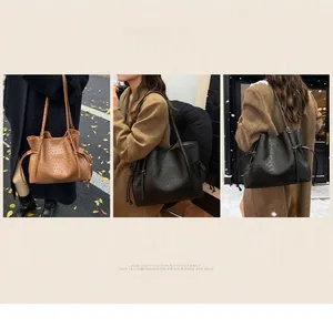 Detail showing ostrich embossed leather texture on black and brown bucket bags