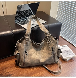 Close-up of a vintage brown leather tote bag with functional pockets in a business setting
