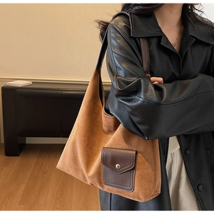 Dettaglio di una borsa tote grande in pelle scamosciata marrone con tasca frontale