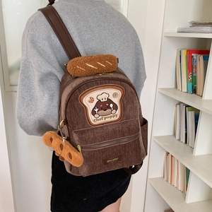 Detail of chef puppy corduroy backpack featuring plush bread-texture handles and embroidery