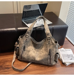Close-up of retro matte leather tote bag featuring functional vertical zipper pockets