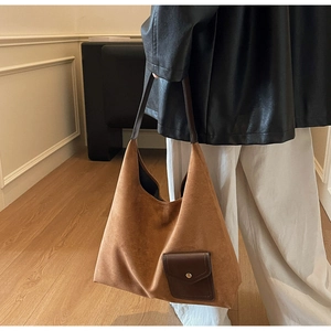 Dettaglio della borsa tote in pelle scamosciata marrone con tasca frontale e fibbia
