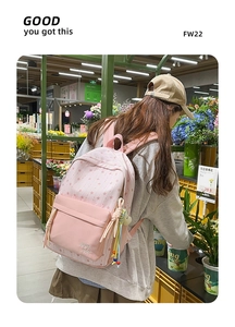 Détail du sac à dos en nylon rose à motifs d'étoiles avec pendentifs décoratifs