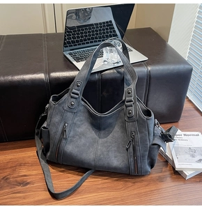 Detail view of large dark grey vintage tote bag with side pockets and smooth matte texture