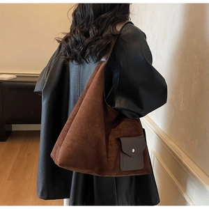 Dettaglio di una borsa tote in pelle scamosciata marrone con tasca e finiture argento