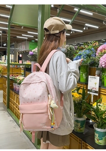 Détail du sac à dos scolaire en nylon rose avec motifs d'étoiles et pendentif lune