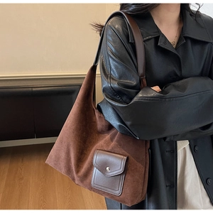 Vista dettagliata della borsa tote in pelle scamosciata marrone con tasca e fibbia in metallo