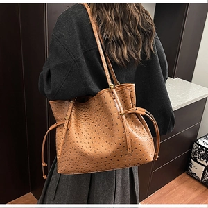 Detail of caramel brown ostrich pattern texture on a large capacity tote shoulder bag
