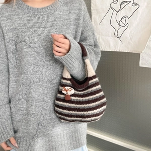 Detail of hand-knitted bucket bag with striped pattern and mushroom patch detail