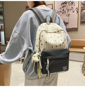 Détail d'un sac à dos d'écolier en nylon avec motif étoiles et pendentif lune