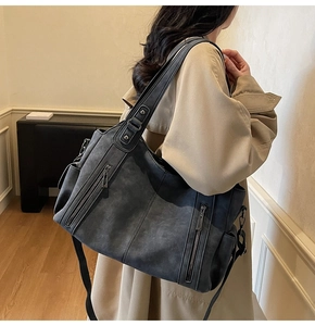 Detailed view of dark grey vintage tote bag with dual zipper pockets and matte leather texture