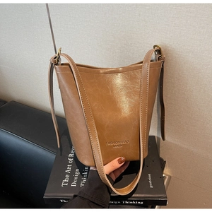 Detailed macro view of the brown vintage bucket bag with polished metal buckle
