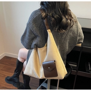 Dettaglio della borsa tote in tela beige con tasca in pelle marrone e bottone a pressione