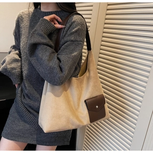 Dettaglio della borsa tote in pelle scamosciata beige con tracolla in pelle marrone