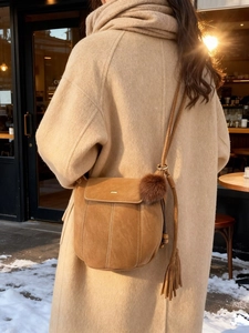 Borsa a secchiello vintage color caramello con pompon e frange per l'inverno
