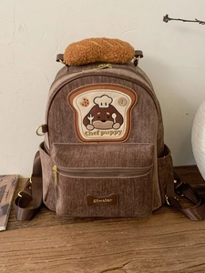 Brown corduroy puppy backpack with cute chef puppy embroidery and plush bread detail