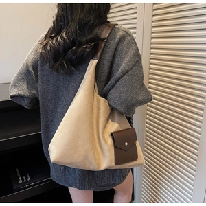 Dettaglio della grande borsa tote in pelle scamosciata beige con tasca in cuoio marrone