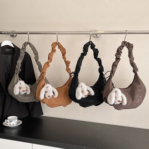 Macro detail of dumpling bags in four colors with cute rabbit charms and pleated straps