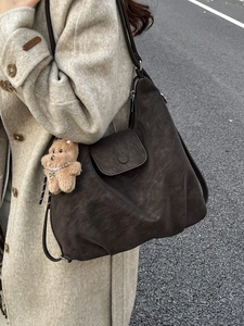 Vintage dark brown large tote bag with teddy charm on a stylish model in wool coat