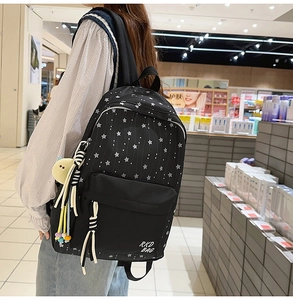 Détail du sac à dos scolaire en nylon noir avec motif étoiles et pendentif canard jaune