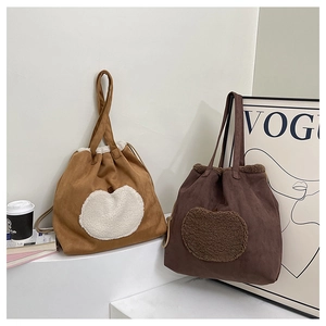 Detail of fleece heart patterns on suede drawstring tote bags in autumn earth tones