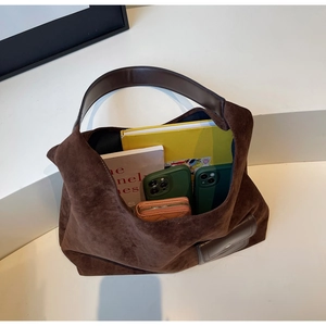 Vista dall'alto dell'interno della borsa tote in pelle scamosciata marrone con oggetti