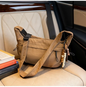 Detailed close-up of brown nylon crossbody bag with colorful wooden beads on car seat