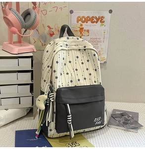 Vue détaillée d'un sac à dos d'école en nylon avec motif étoiles et pendentif lune