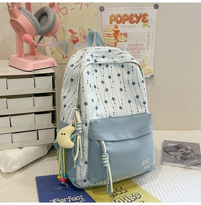 Vue détaillée du sac à dos d'école en nylon rayé avec motif étoilé et pendentif lune