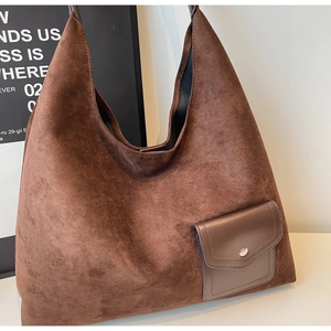 Detail of dark brown suede hobo bag featuring a matte leather pocket with metal button