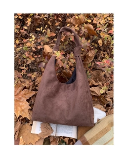 Detail view of brown matte suede tote bag with stylish knot design on shoulder strap