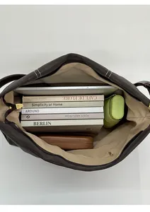 Top view of spacious brown tote interior with laptop and books showing large capacity