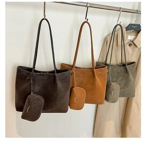 Three colors of retro tote bags with matching pouches hanging on a metal rack