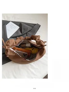 Macro shot showing the spacious interior of this brown pleated bag with daily essentials