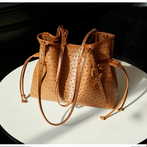 Detail of ostrich leather texture on large brown bucket bag with gold hardware