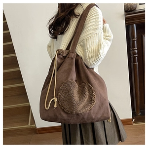 Detail of vintage brown suede tote bag with heart embroidery and drawstring closure
