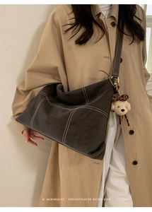 Detail of dark taupe matte tote bag with contrast stitching and leopard print puppy charm